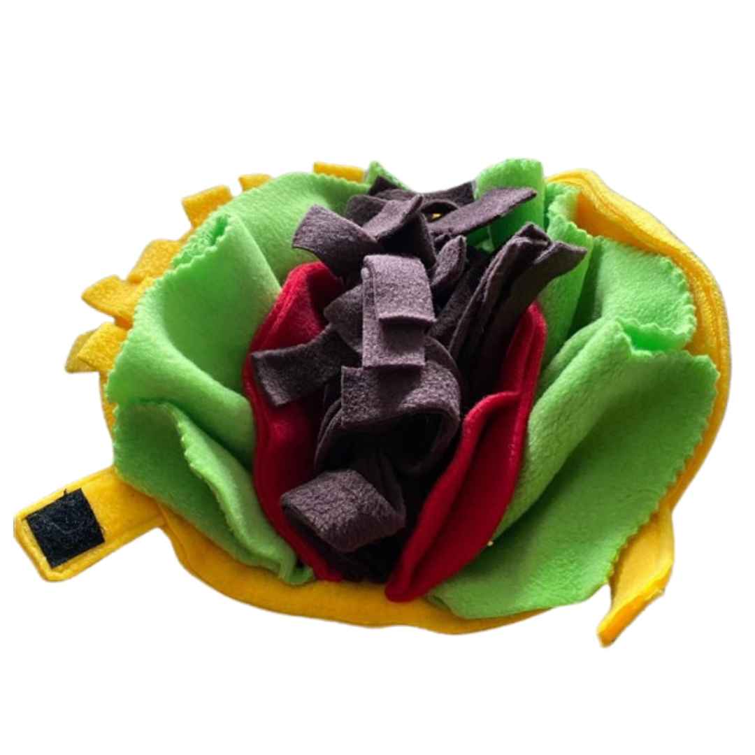 A colour image of a handmade dog toy in the style of a taco. It is made from yellow, green, red and brown fleece fabric and opens to lay flat or close.