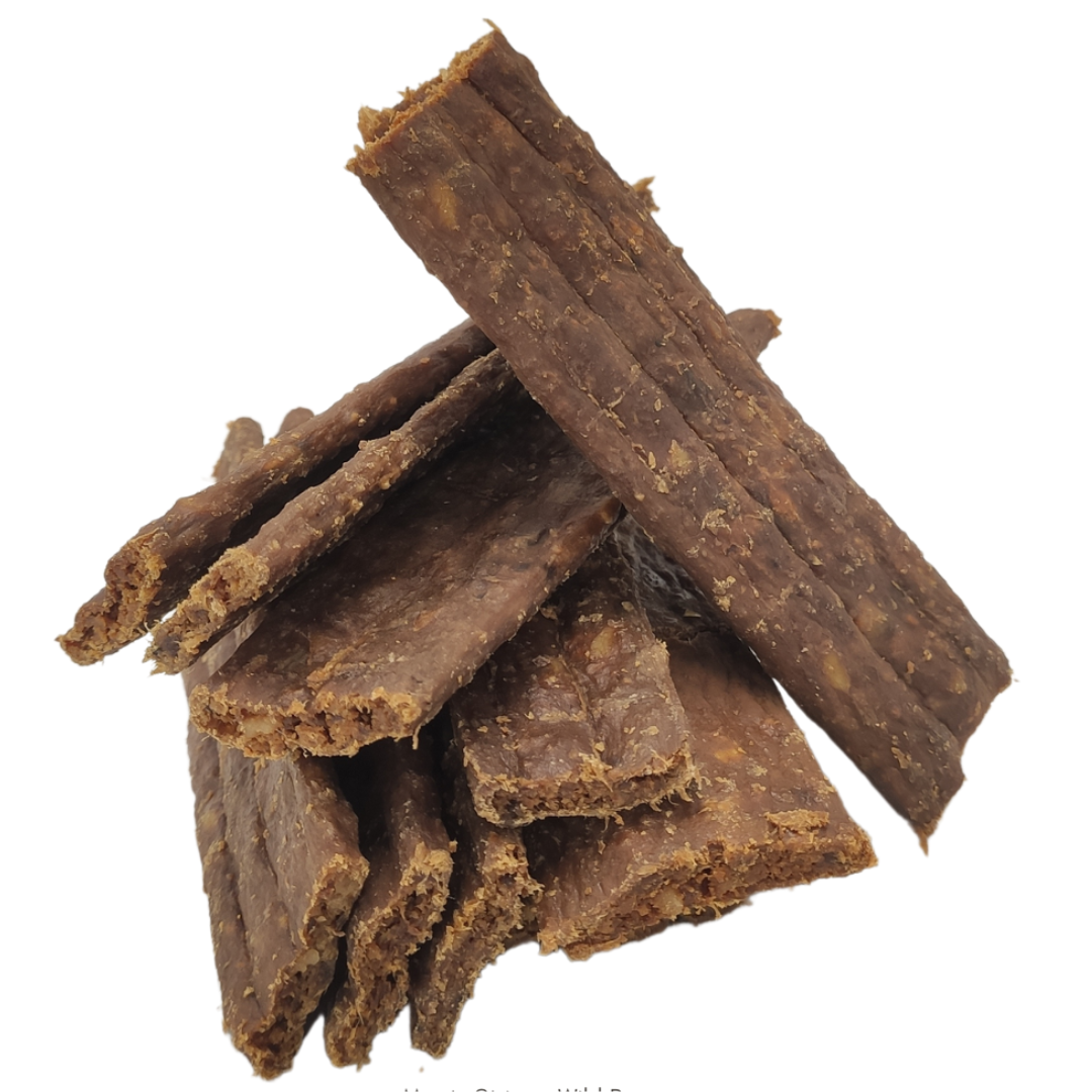 A colour image of a pile of meaty strip natural dog treats